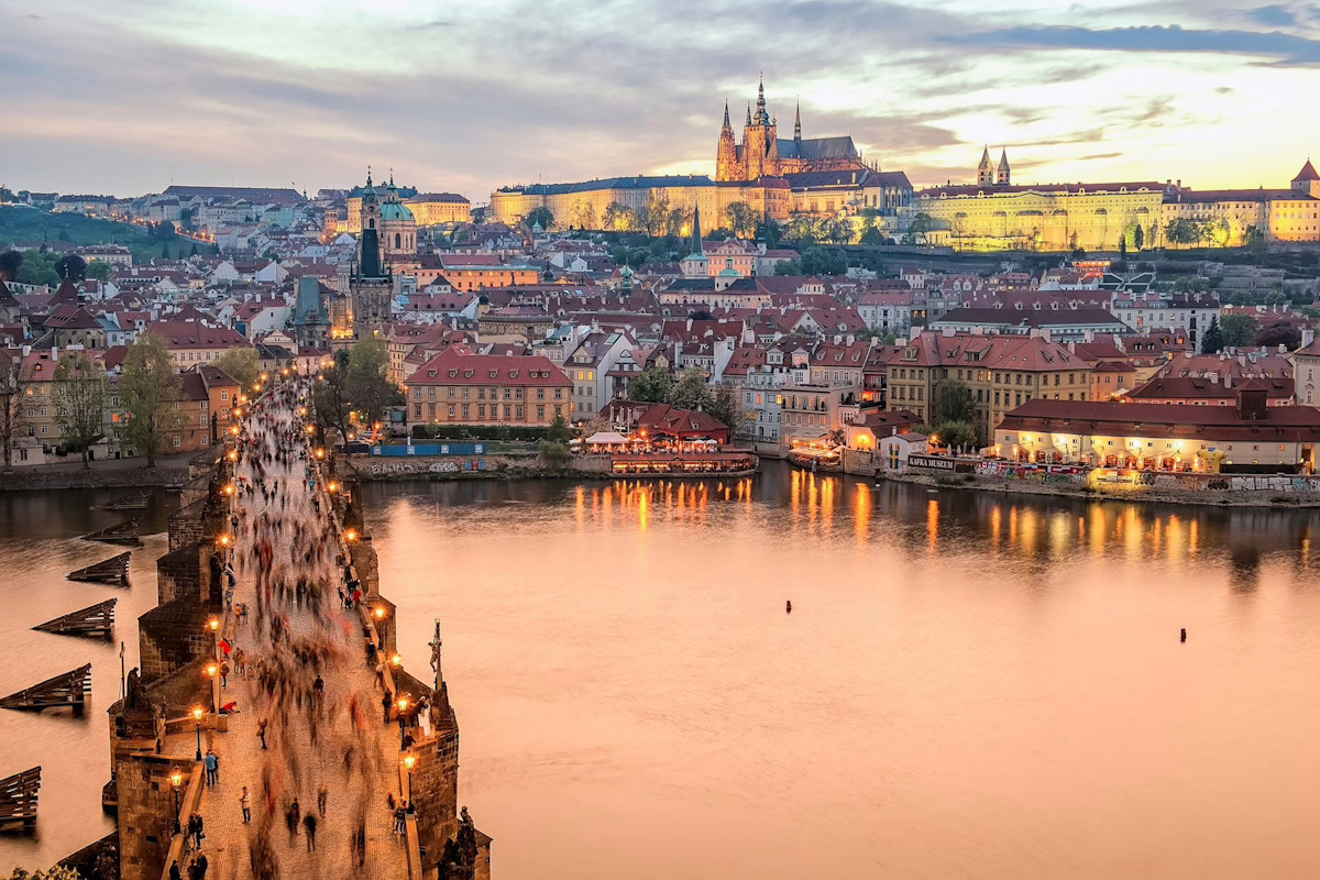 Image shows the skyline of Prague at dusk